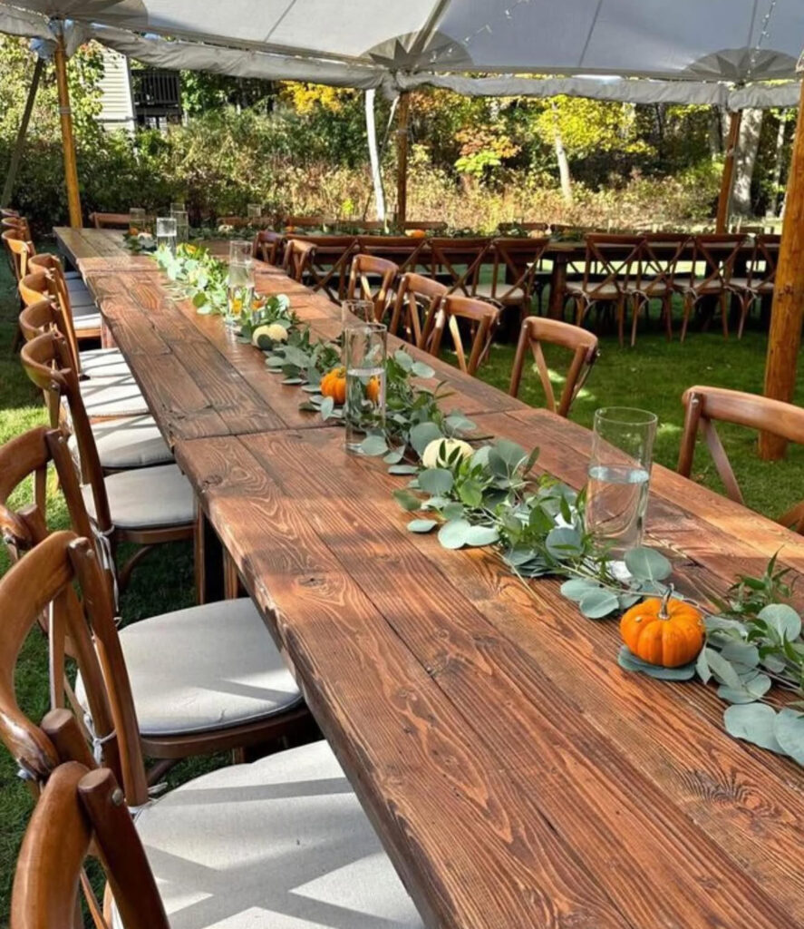 Rustic farm table set with greenery and crossback chairs
